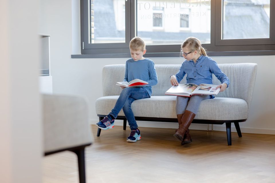 Kinder lesen im Wartebereich